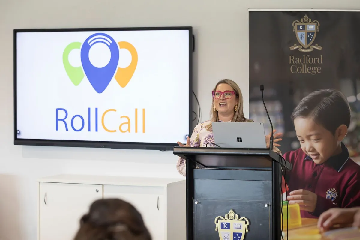Amanda from RollCall speaking at a lectern at Radford College, with the RollCall logo on screen